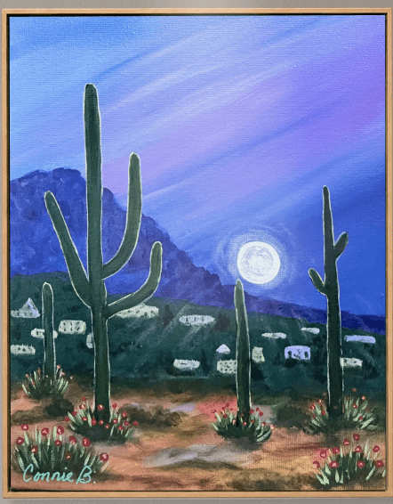 Saguaro cacti under a full moon over desert hills