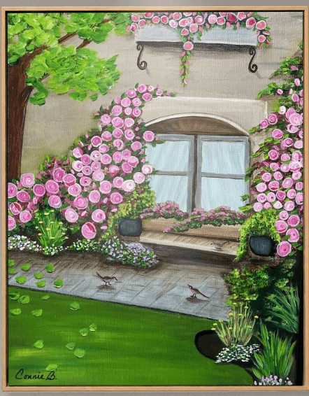 View through a rose-framed window onto a sunlit garden